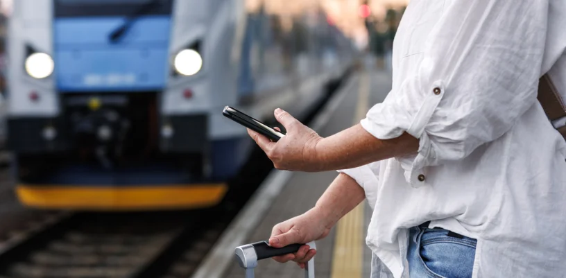 woman looking at phone on train platform